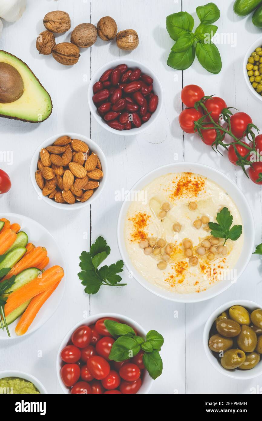 Cibo vegano verdure sfondo sano organico su una tavola di legno formato verticale moody Foto Stock