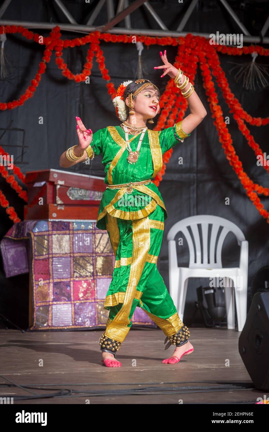 Una ballerina indiana femminile in un elegante costume verde e oro che si esibisce durante Diwali, il festival indù della luce Foto Stock
