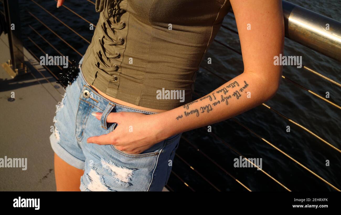 Giovane ragazza che indossa una camicia medievale con un tatuaggio con caratteri di scrittura nella sua mano sinistra. Foto Stock