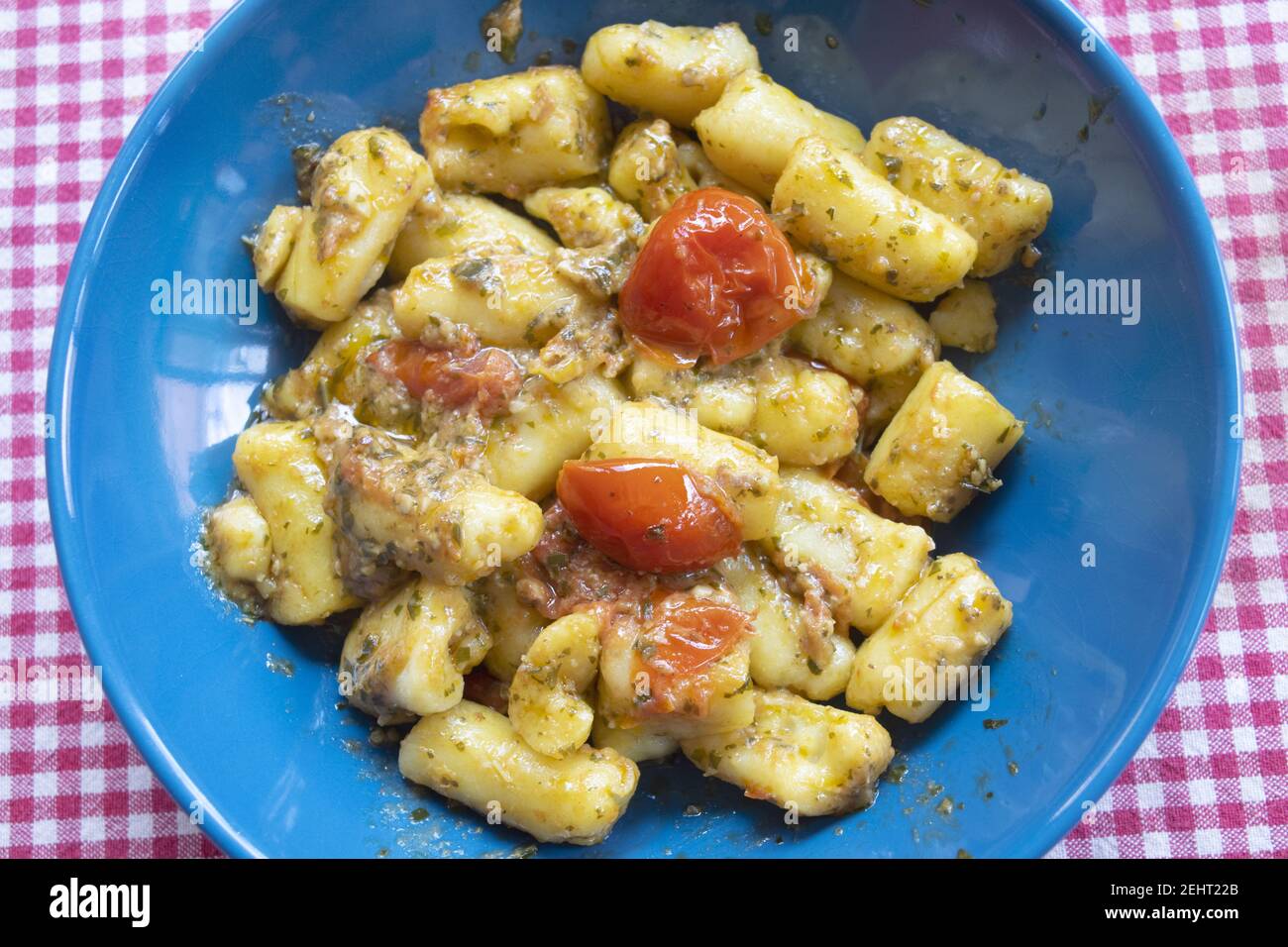 gnocchi di patate con salsa al pesto e pomodori ciliegini Foto Stock