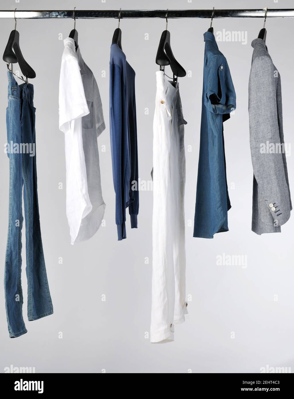 Set di abiti eleganti e alla moda da uomo appesi in un negozio per la  vendita Foto stock - Alamy