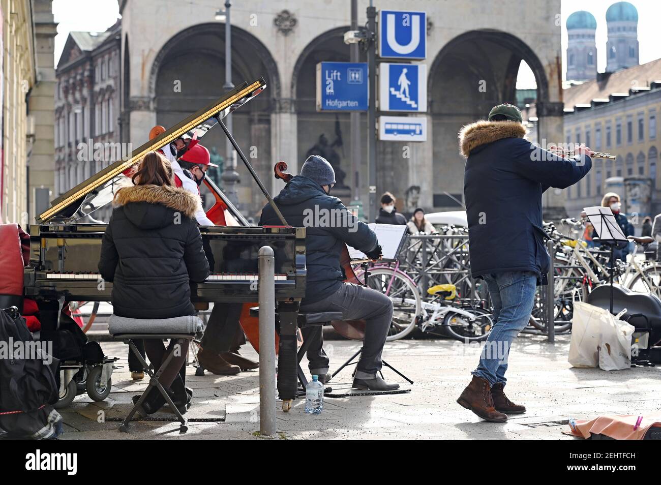 Musicisti di strada in tempi della pandemia del coronavirus: I musicisti suonano musica classica il 19 febbraio 2021 all'ingresso di Odeonsplatz / Hofgarten a Monaco e chiedono donazioni, pubblicizzano spettacoli e vendono supporti sonori, CD e CD. | utilizzo in tutto il mondo Foto Stock