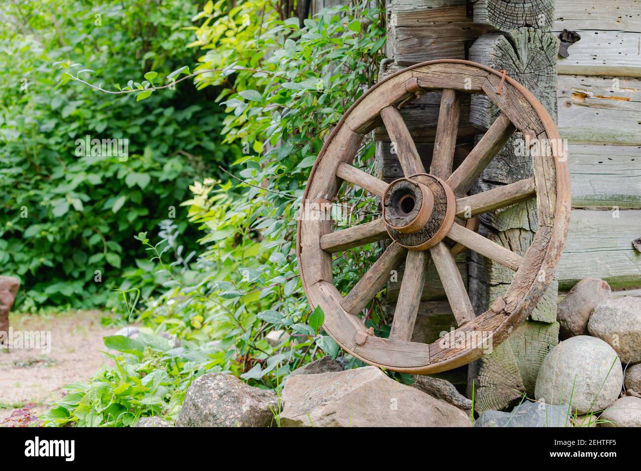 Vecchia ruota di legno nel willage vicino a vecchia casa wodden in Lituania Foto Stock