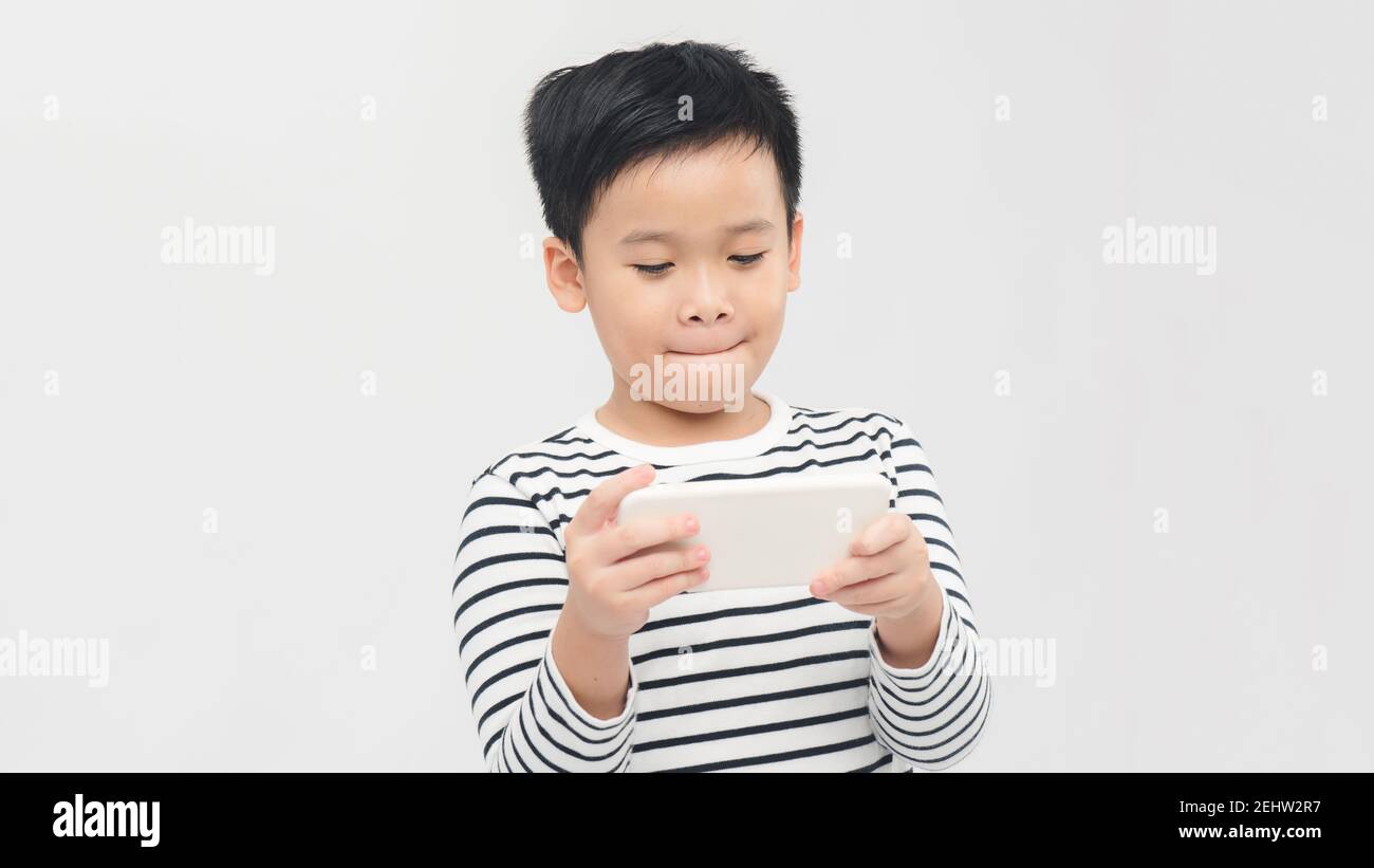 Divertito piccolo ragazzo a giocare su smartphone - posare a. studio Foto Stock