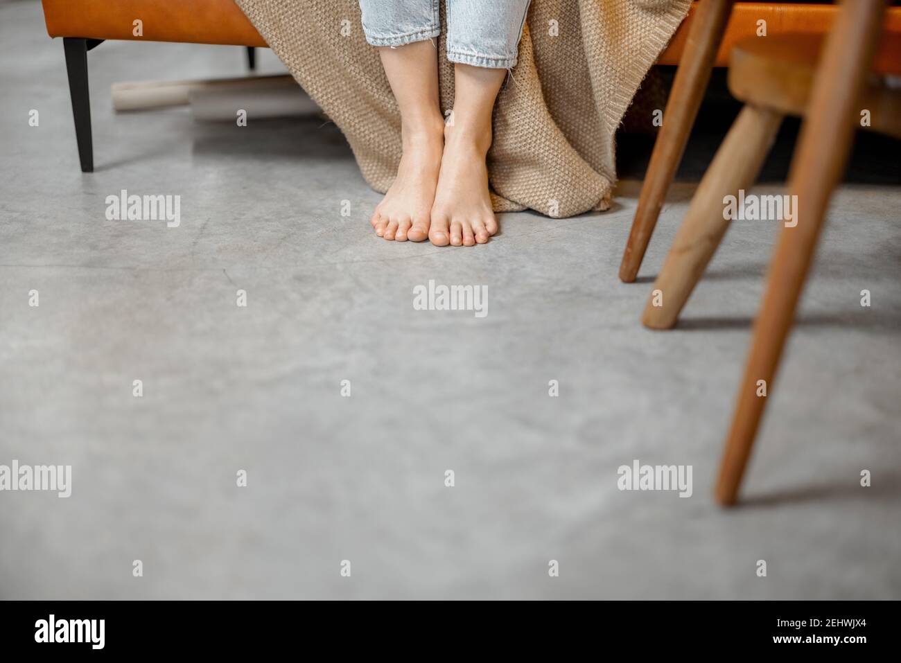 Le gambe della donna sul pavimento mentre lavora con il computer portatile Foto Stock