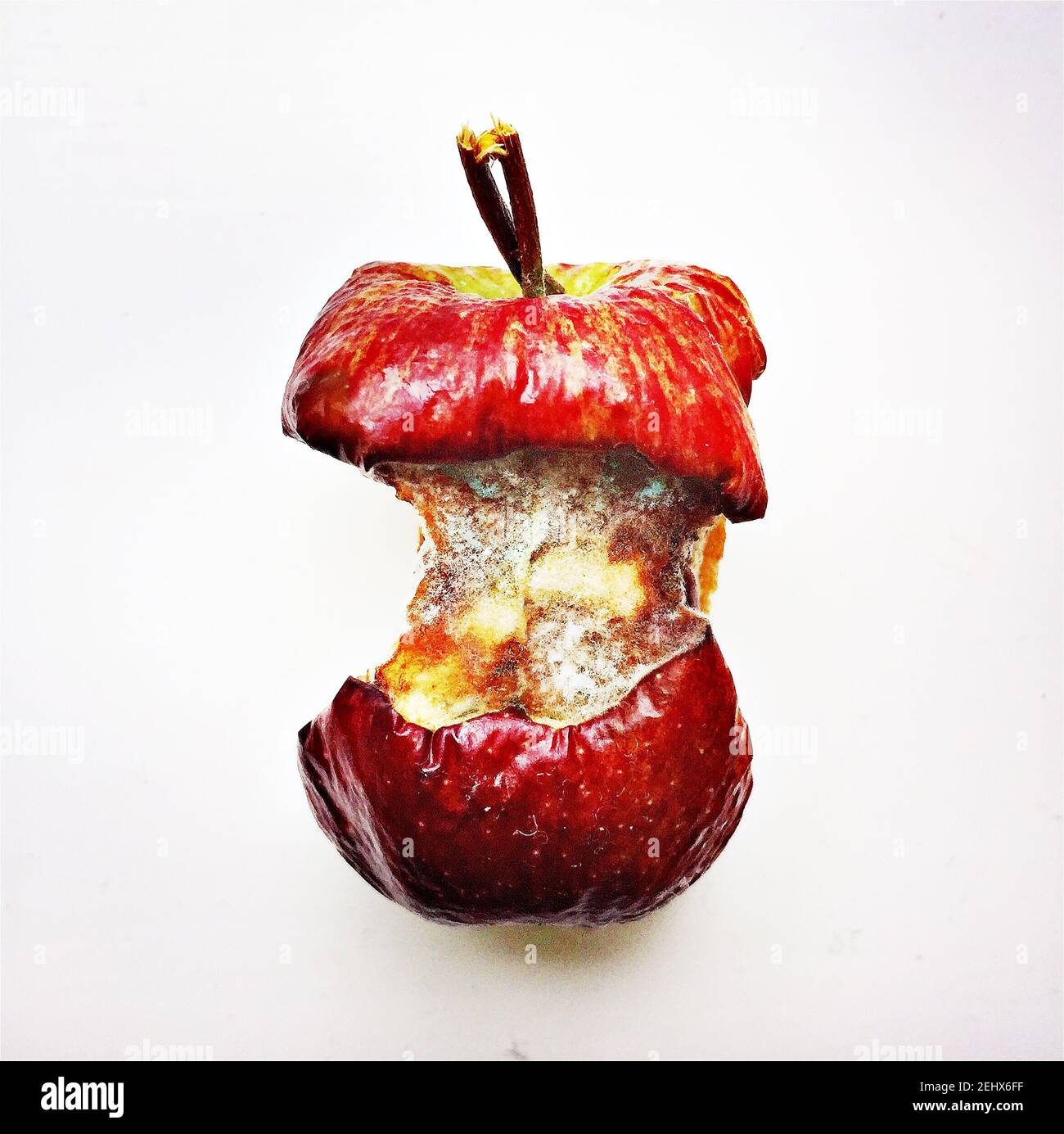 Anima di mela ammuffita con pelle rossa su sfondo bianco Foto Stock