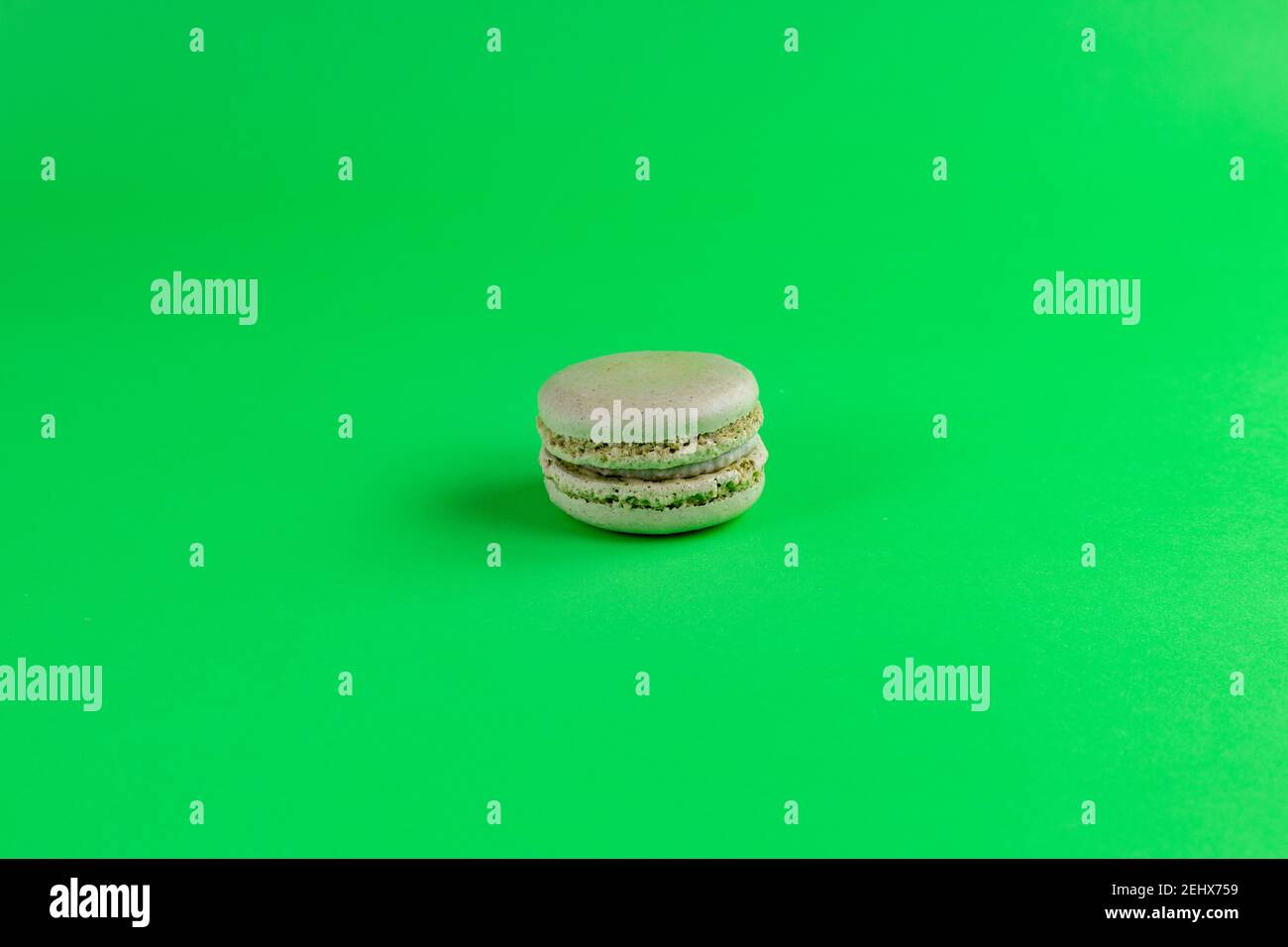 macaroon pistacchio isolato con fondo verde Foto Stock
