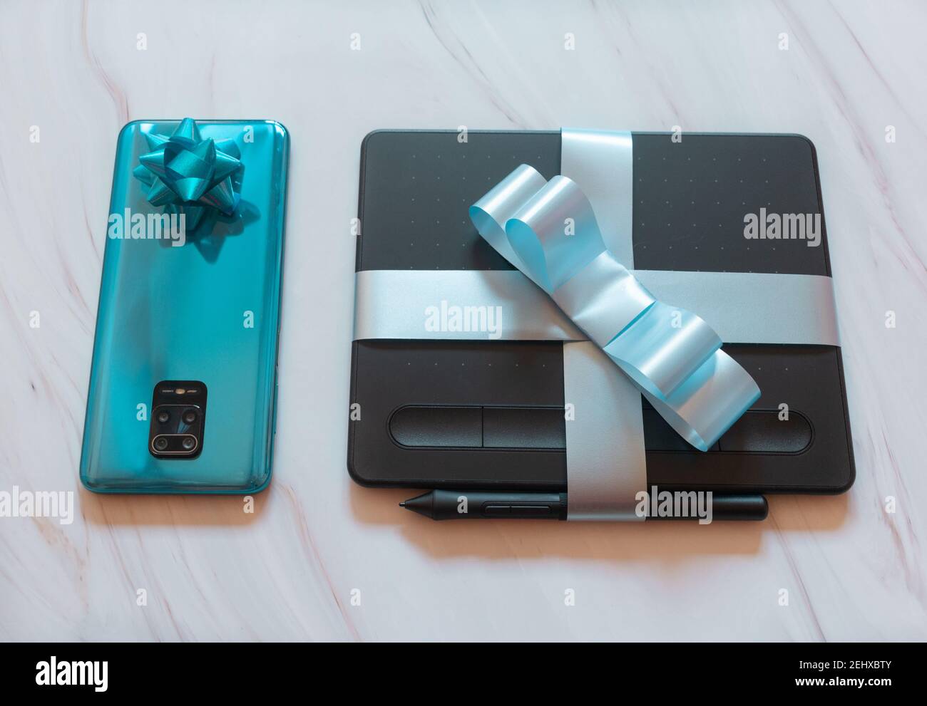 tablet digitale con dispositivi mobili avvolti con nastri blu Foto Stock