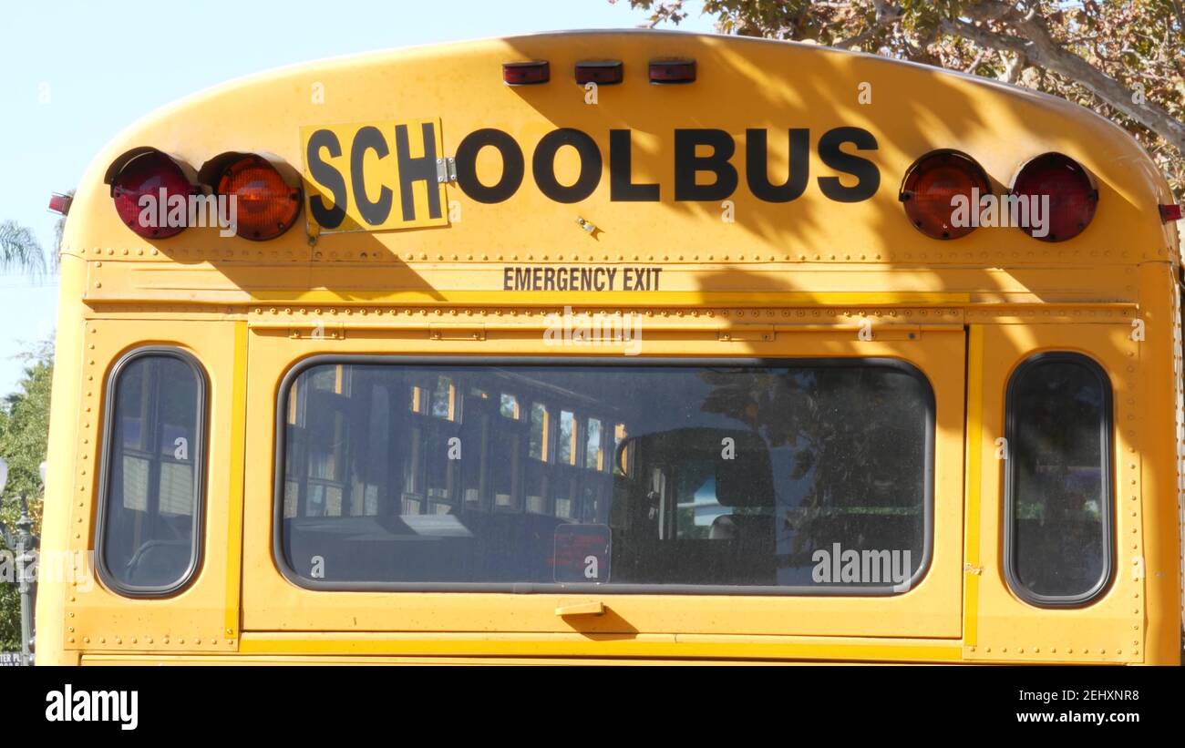 Autobus scolastico giallo iconico a Los Angeles, California USA. Veicolo classico per studenti vista posteriore. Luci di arresto del veicolo per la sicurezza del trasporto di bambini Foto Stock