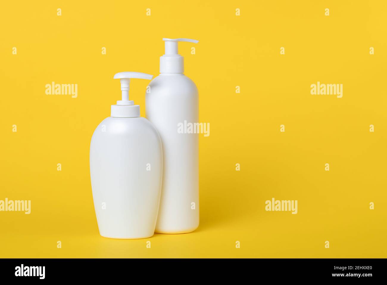 Sapone liquido in una pancetta. Set di flaconi in plastica con dispenser su fondo giallo. Spazio per la copia, vuoto per il testo. Lozione pompa. Cré idratante Foto Stock