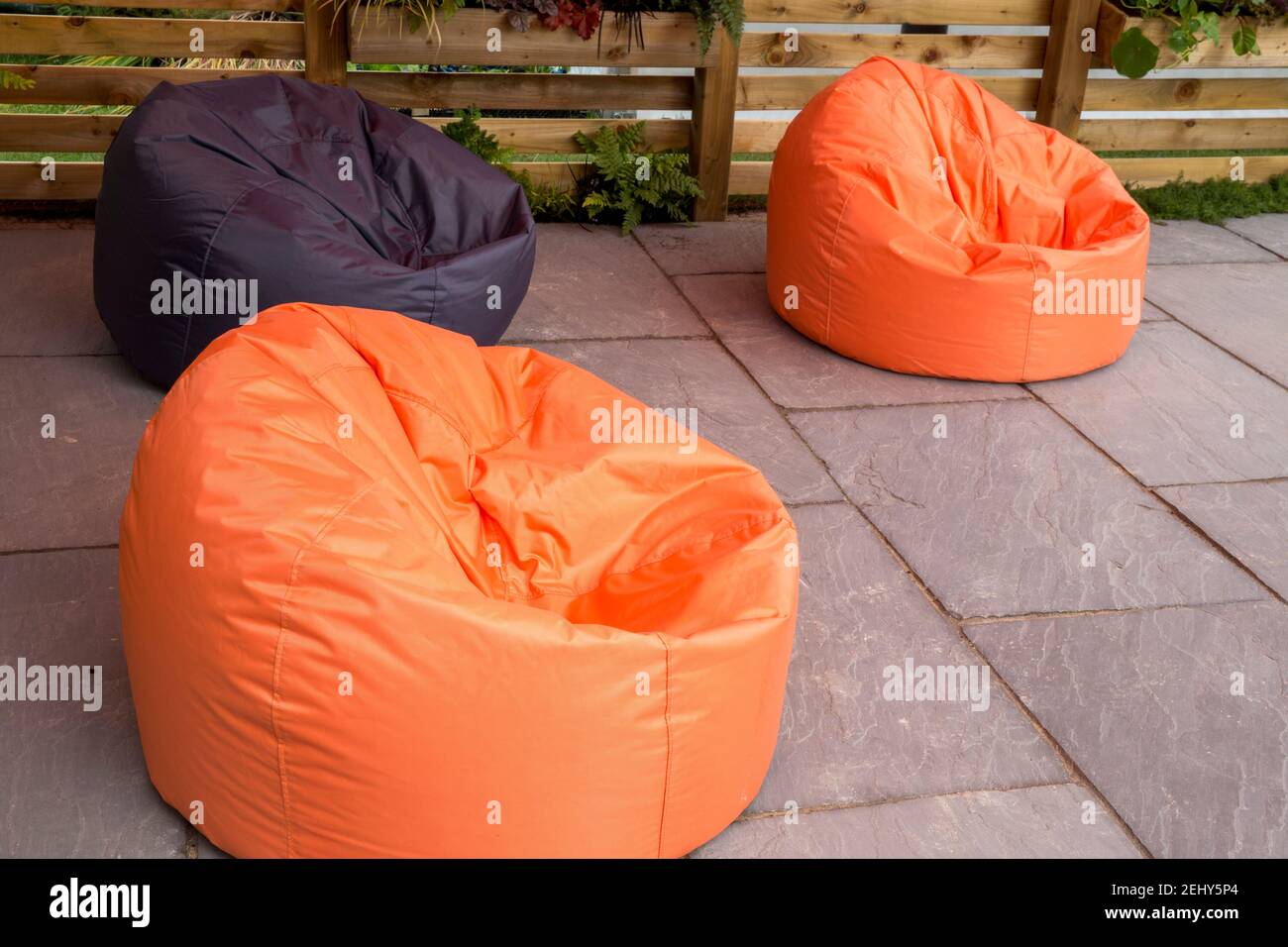 Grandi beanbag arancioni e nere sedute su una pietra Patio lastricato Inghilterra GB UK Foto Stock