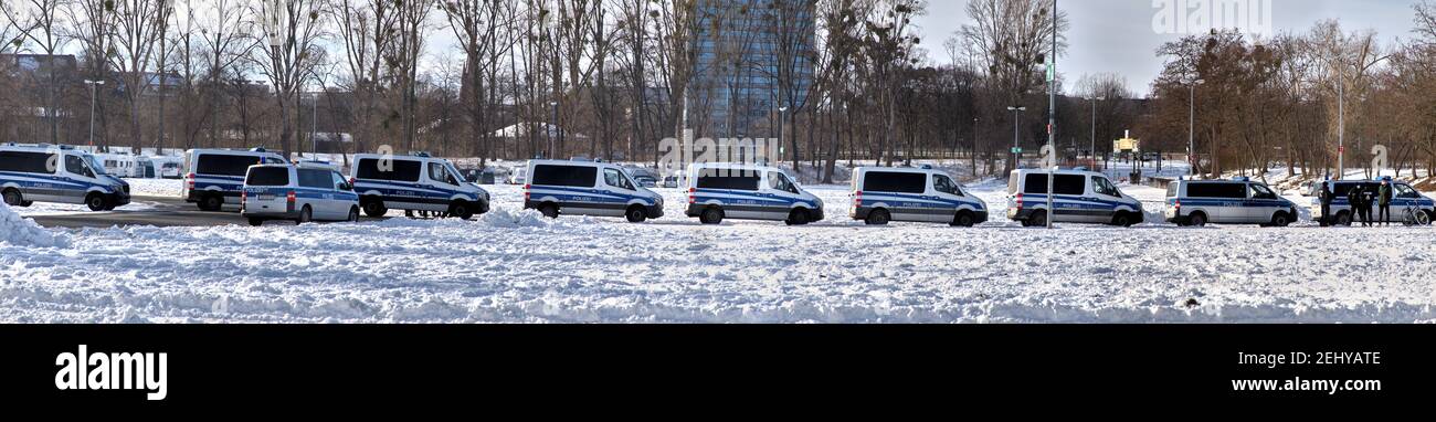 Hannover, Germania, 14 febbraio 2021: Panorama di una lunga fila di furgoni di polizia dietro un'area coperta di neve alta Foto Stock