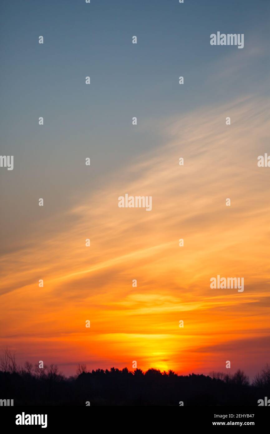 Cielo colorato del tramonto e nuvole con luce drammatica e spazio di copia, verticale Foto Stock