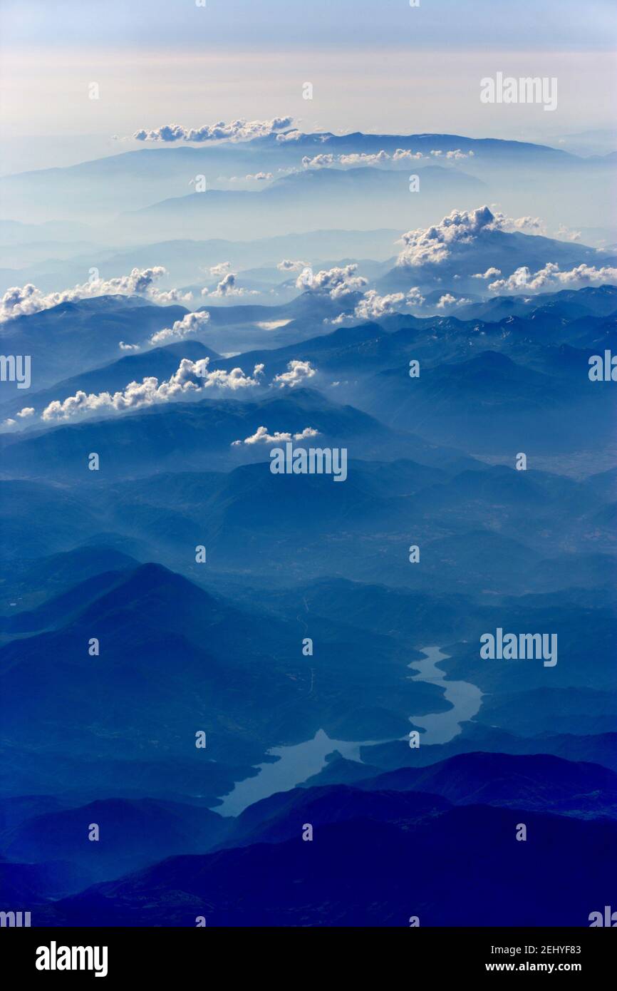 Fotografia aerea di Blue Foggy Mountains con Nubi e un Fiume Foto Stock