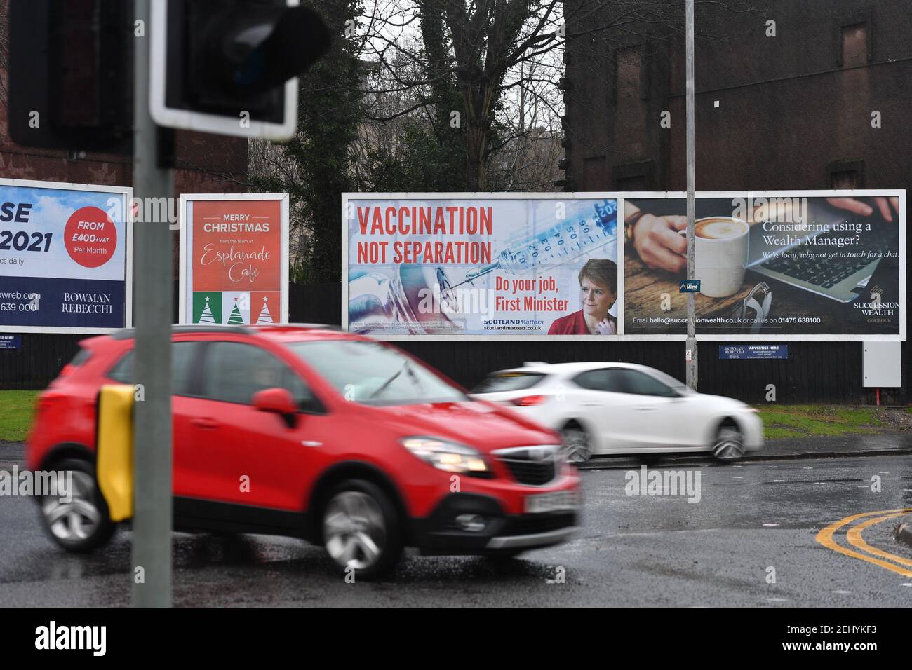 Greenock, Scozia, Regno Unito. 20 febbraio 2021. Nella foto: Immagine del primo ministro scozzese Nicola Sturgeon con la grafica di un vaccino COVID19 e una siringa con lo slogan: "VACCINAZIONE NON SEPARAZIONE. FAI IL TUO LAVORO, PRIMO MINISTRO." su un cartellone nel mezzo di Greenock, in un crocevia trafficato di Brougham St & Campbell St. Questo è in riferimento alla maggioranza silenziosa di persone in Scozia che si oppongono alla SNP cercando un secondo referendum sull'indipendenza nel mezzo di una pandemia che lo ha fatto Nel Regno Unito sono state uccise oltre 106,000 persone, di cui 6,816 nella sola Scozia. Credit: Colin Fisher/Alamy Live News. Foto Stock