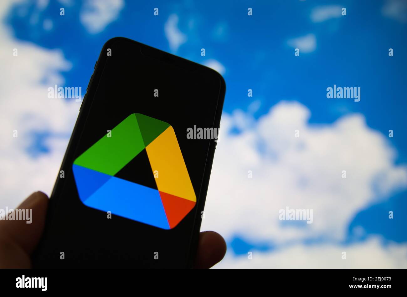 Viersen, Germania - 9 febbraio. 2021: Primo piano dello smartphone con la scritta del logo del provider di servizi di cloud computing google, cielo sfocato e backg cloud Foto Stock