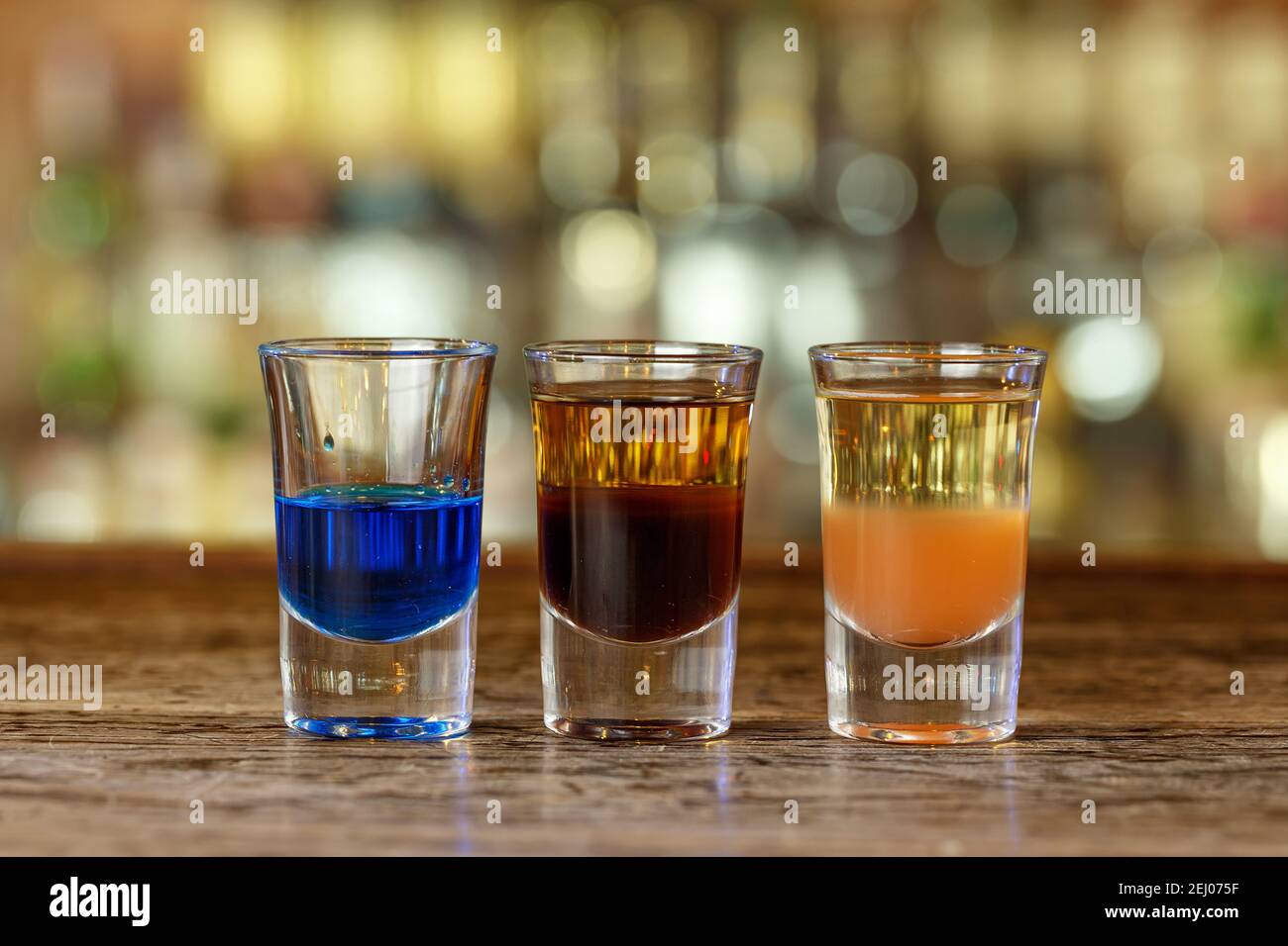 Cocktail party in un nightclub, bevande colorate in piedi su un banco bar in legno Foto Stock