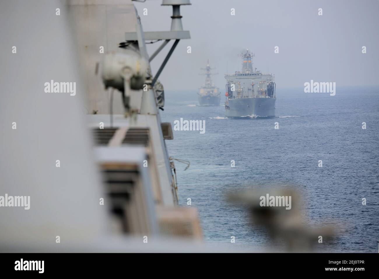 Il cacciatorpediniere guidato-missile USS John Paul Jones della marina degli Stati Uniti, il rifornitore militare della flotta di comando di Sealift USNS Patuxent e la nave da carico anfibia di classe San Antonio USS San Diego, parte del gruppo di pronto anfibio dell'isola di Makin, transitano nello stretto di Hormuz febbraio 19, 2021 al largo della costa di Oman. Foto Stock