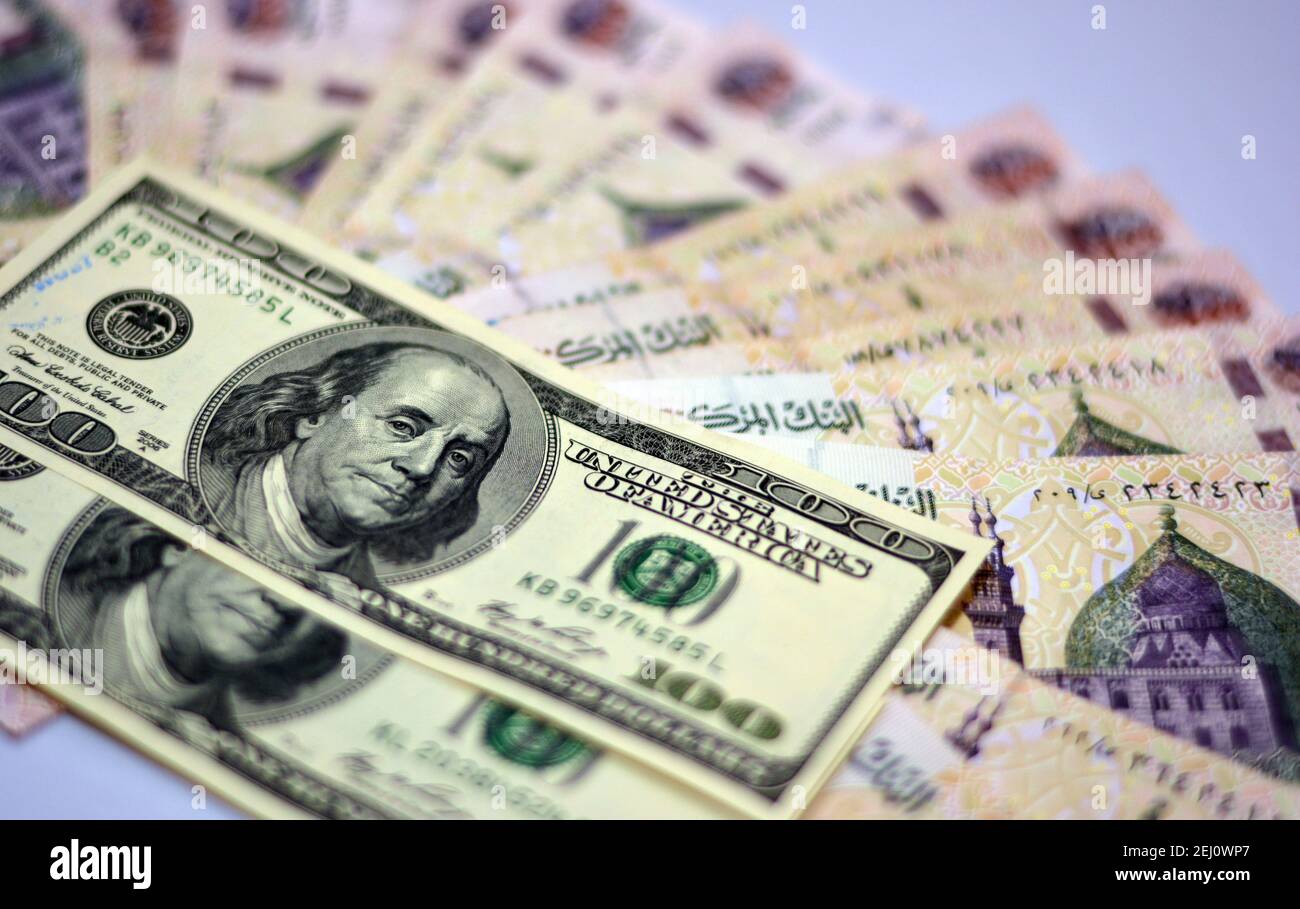 Fuoco selettivo della valuta nazionale dell'Egitto con le banconote del dollaro degli Stati Uniti. Soldi offuscati . Valuta egiziana e tasso di cambio dollari americani,. Foto Stock