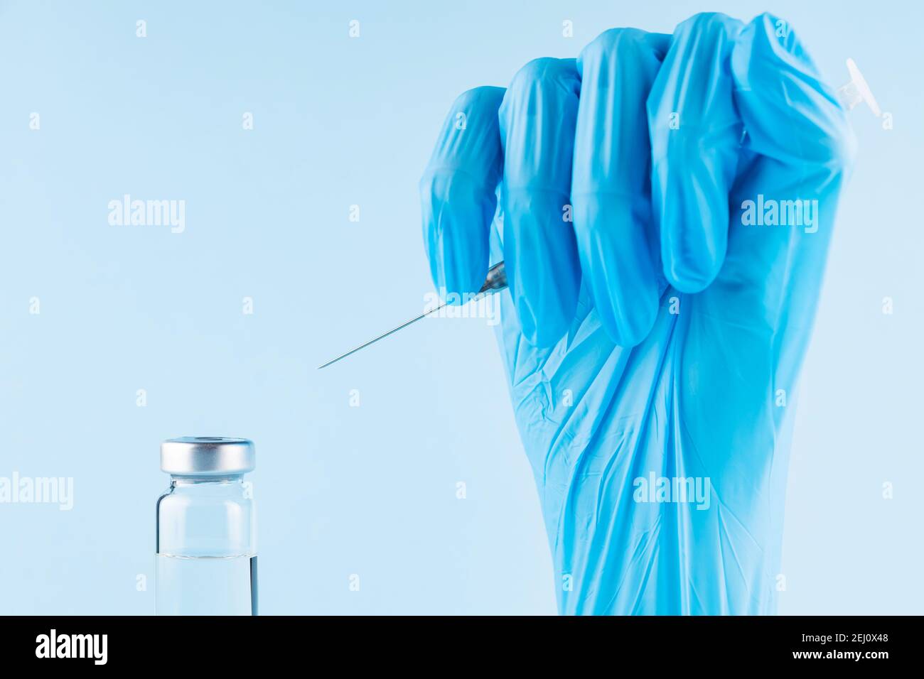 Siringa di riempimento manuale con farmaco. Braccio robotico in siringa porta guanti chirurgici con vaccino Covid-19. Concetto di vaccinazione e immunizzazione. Copia Foto Stock