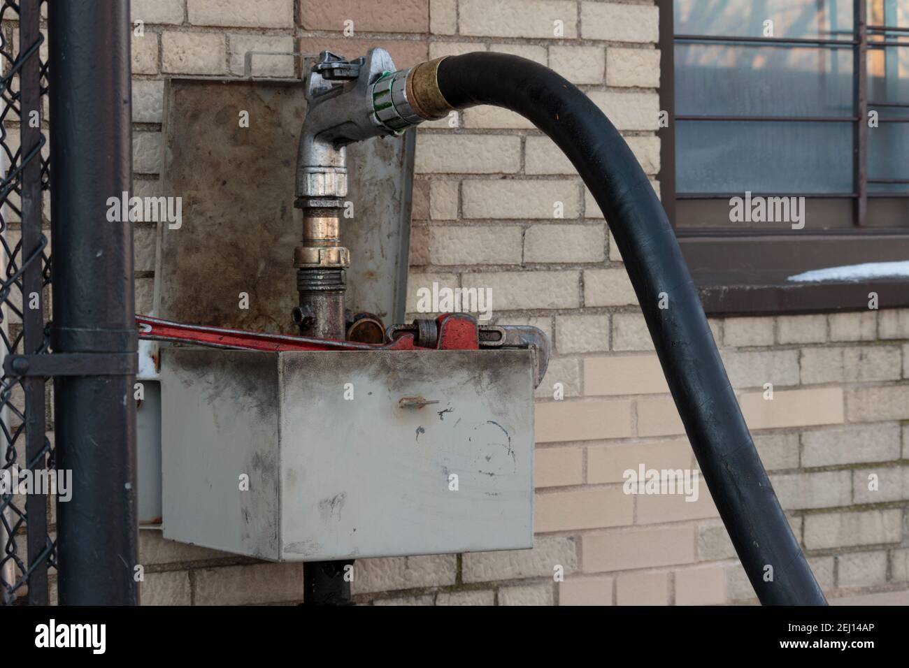 l'ugello di una pompa di riempimento dell'olio di riscaldamento è agganciato al tubo di sfiato di un serbatoio dell'olio di riscaldamento di un edificio residenziale di appartamenti Foto Stock