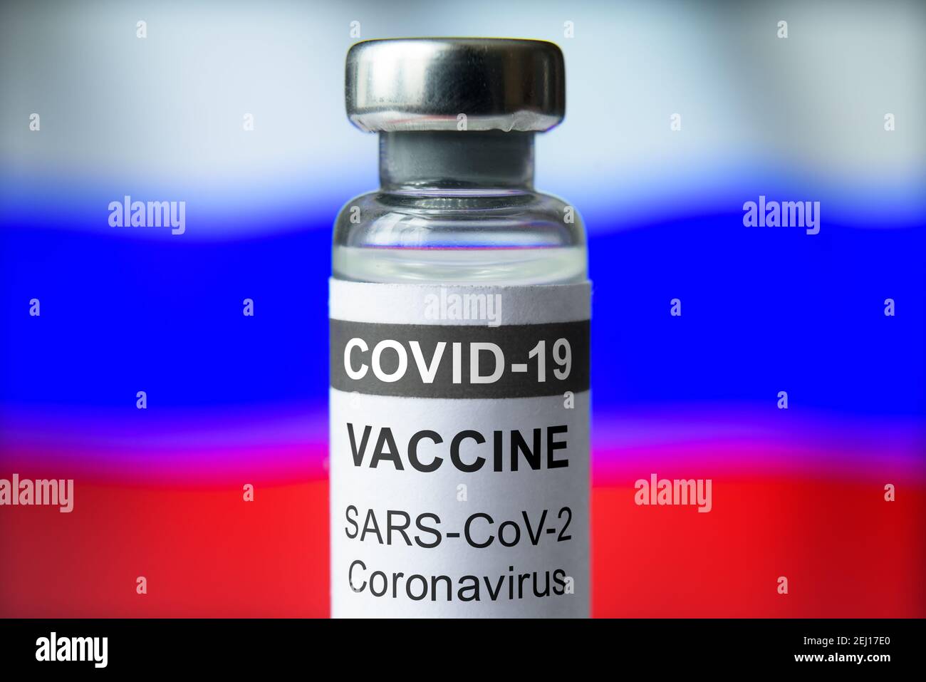 Vaccino COVID-19 su fondo bandiera russa, flacone con vaccino Sputnik V per coronavirus primo piano. Concetto di trattamento, sperimentazione clinica, distribuzione Foto Stock