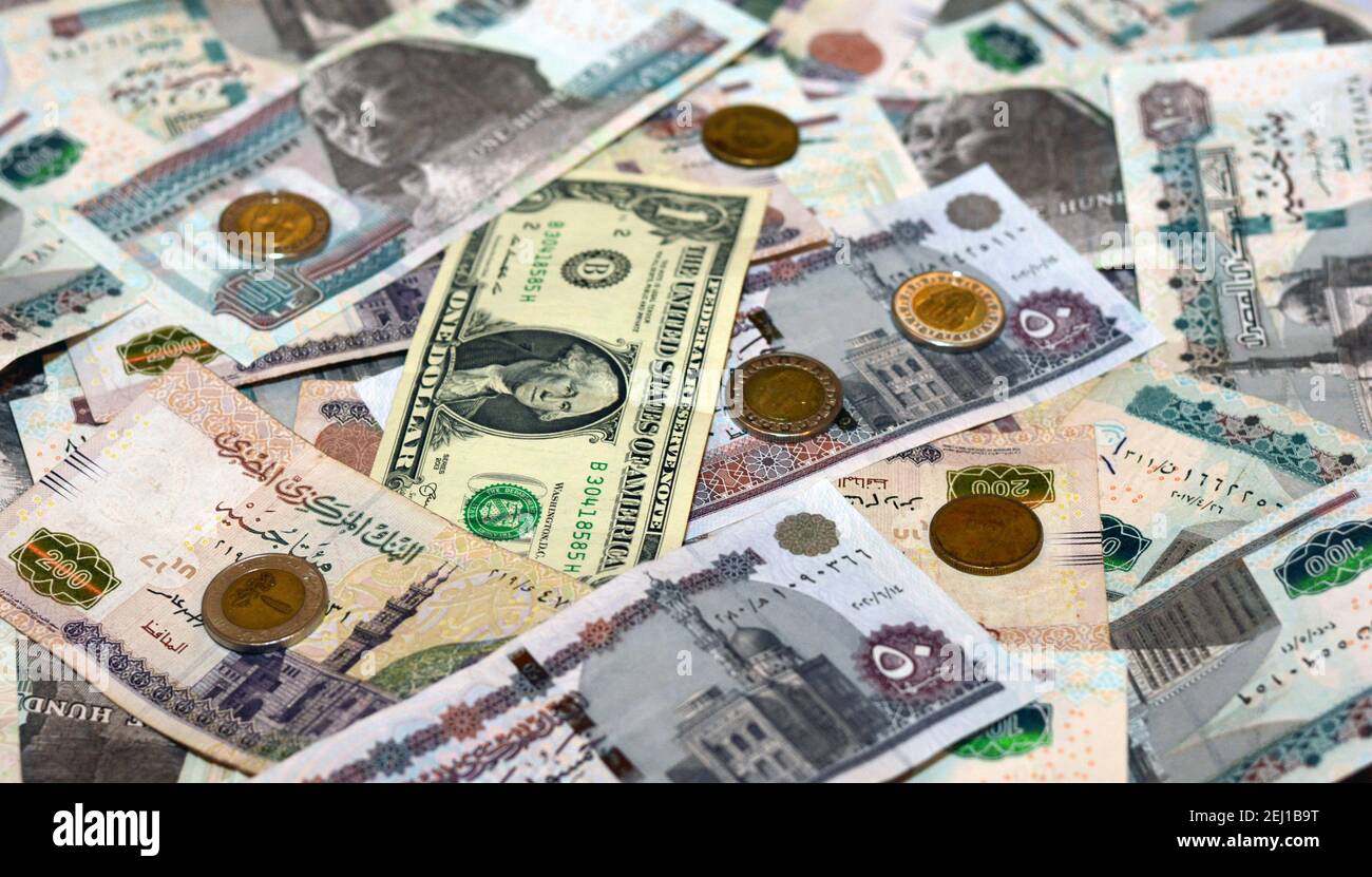 Valuta nazionale egiziana con sfondo di banconote in dollari USA. Sterline egiziane e tasso di cambio in dollari americani Foto Stock