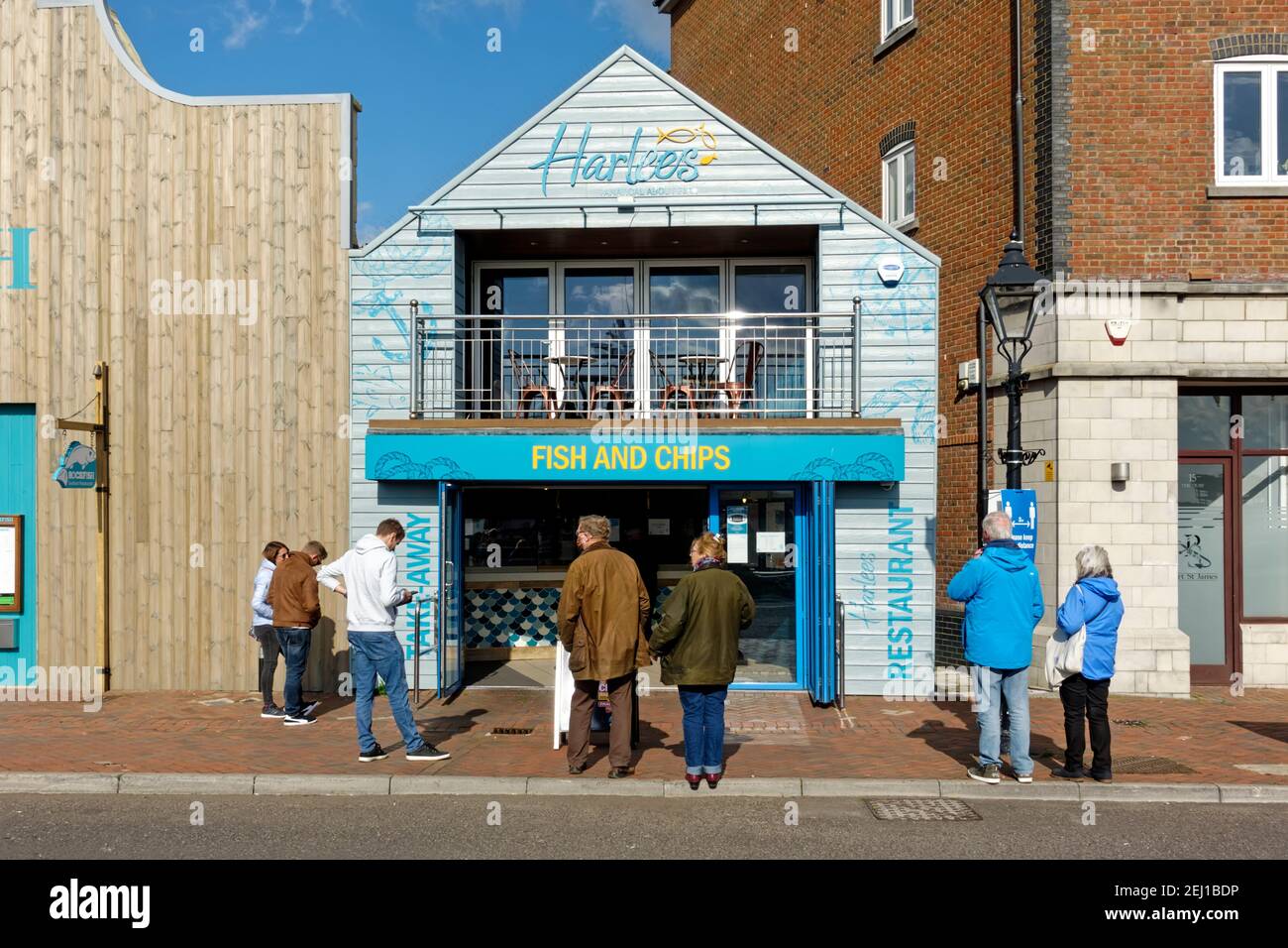 Poole, Dorset, UK - Ottobre 14 2020: La gente coda fuori Harlees pesce e negozio di chip su Poole Quay Foto Stock