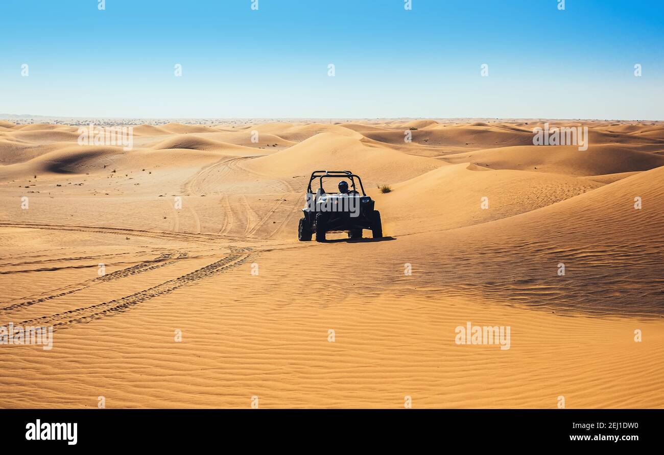 Giro in quad in buggy in avanti sulla sabbia del deserto, lascia tracce, splendido paesaggio naturale selvaggio, guida fuori strada all'aperto Foto Stock