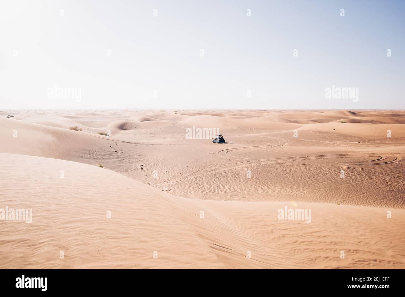 Bella luce caldo silenzioso deserto paesaggio con guida nero buggy quad lontano, al Awir (Aweer) vista dune di sabbia, Dubai, Emirati Arabi Uniti Foto Stock