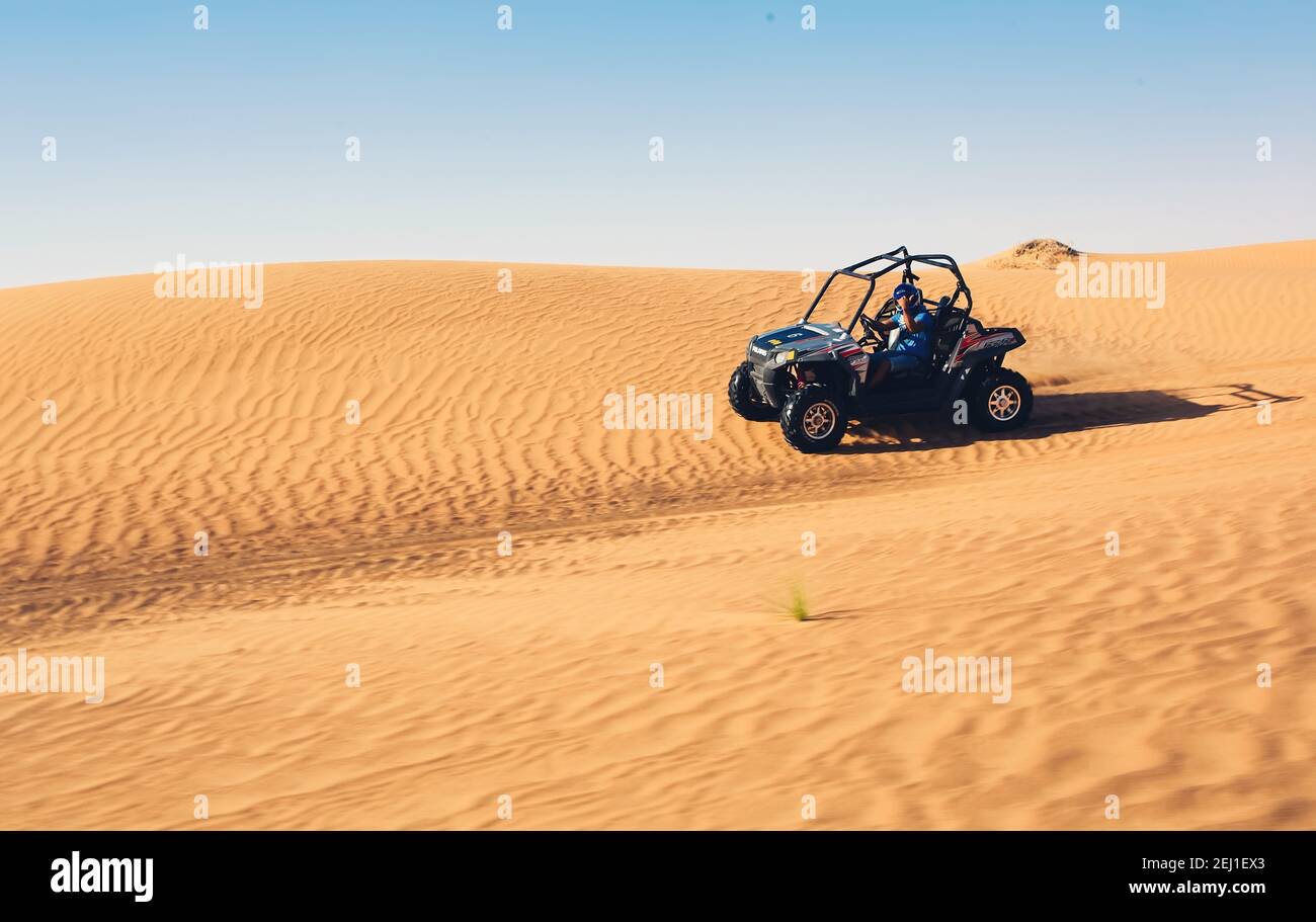 Quad buggy bike driver in casco scendendo dalla sabbia tour safari in collina nel deserto Foto Stock