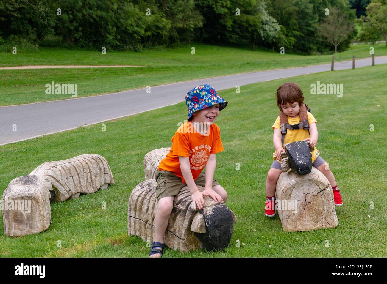 Bambini che giocano in un campo con alcuni animali di legno Foto Stock