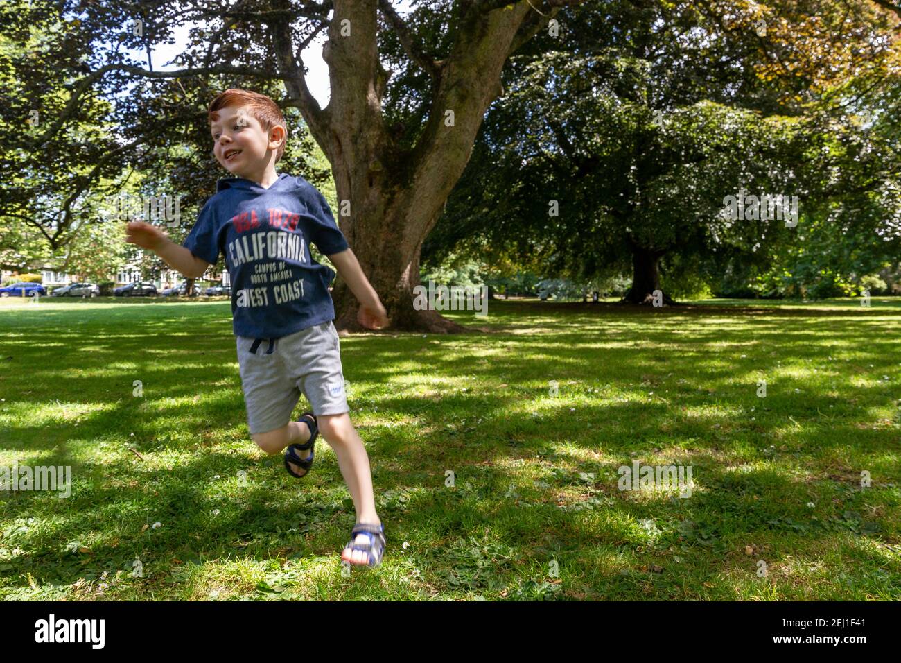 Un ragazzo in esecuzione in un parco Foto Stock
