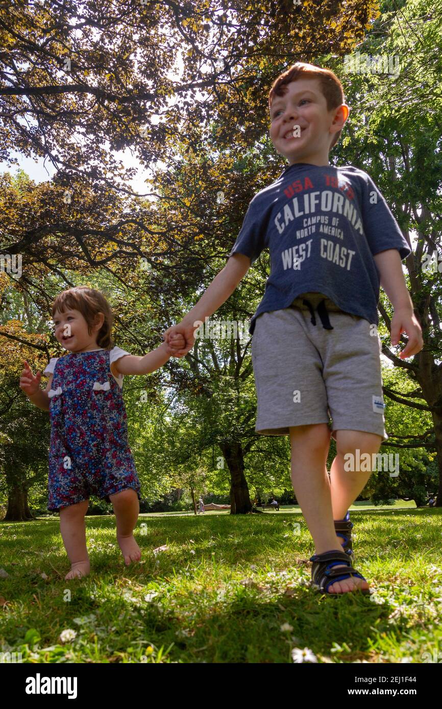 Un ragazzo e una ragazza che tengono le mani in un parco Foto Stock