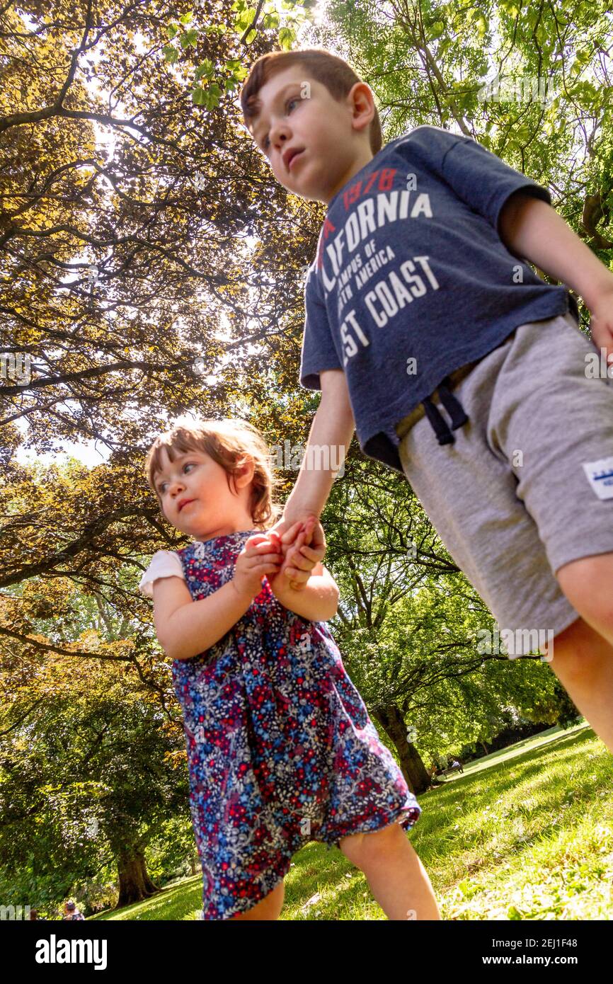 Un ragazzo e una ragazza che tengono le mani in un parco Foto Stock