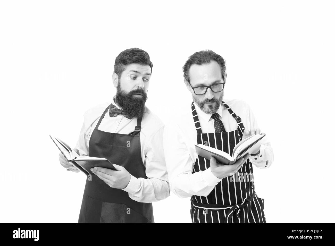 Alcuni problemi. I doveri della famiglia. Cucina ricette alimentari. Come cucinare. Uomini portatori Hipster cuoco grembiule lettura libri su culinario. Non c'è idea di come cucinare il cibo. Concetto di libro culinario. Uomini in carica di famiglia. Foto Stock