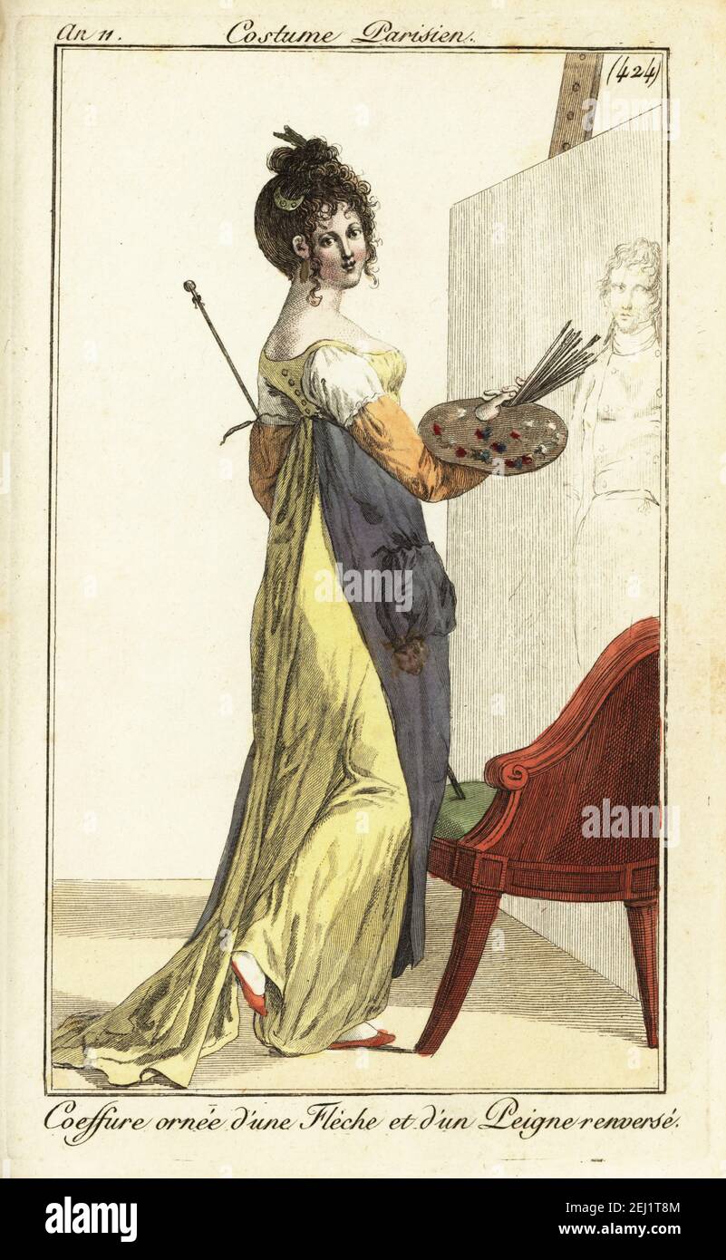 Artista donna di fronte ad un dipinto ad olio con palette e pennelli. Indossa un grembiule e maniche protettive su un abito giallo a taglio basso. Il suo capelli è ornato con una freccia e un pettine. Coiffure ornée d'une Flèche et d'un Peigne renversé incisione a mano su copperplate dal Journal des Dames et des Modes di Pierre de la Mesangere, Magazine of Women and Fashion, Parigi, AN 11, 1802. Illustrazioni di Carle Vernet, Jean-Francois Bosio, Dominique Bosio e Philibert Louis Debucourt, incise da Pierre-Charles Baquoy. Foto Stock