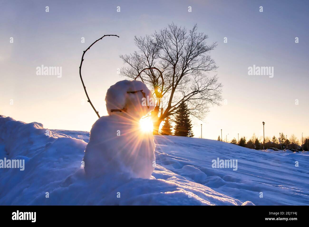 Snowman su un tramonto invernale con lente-flare Foto Stock