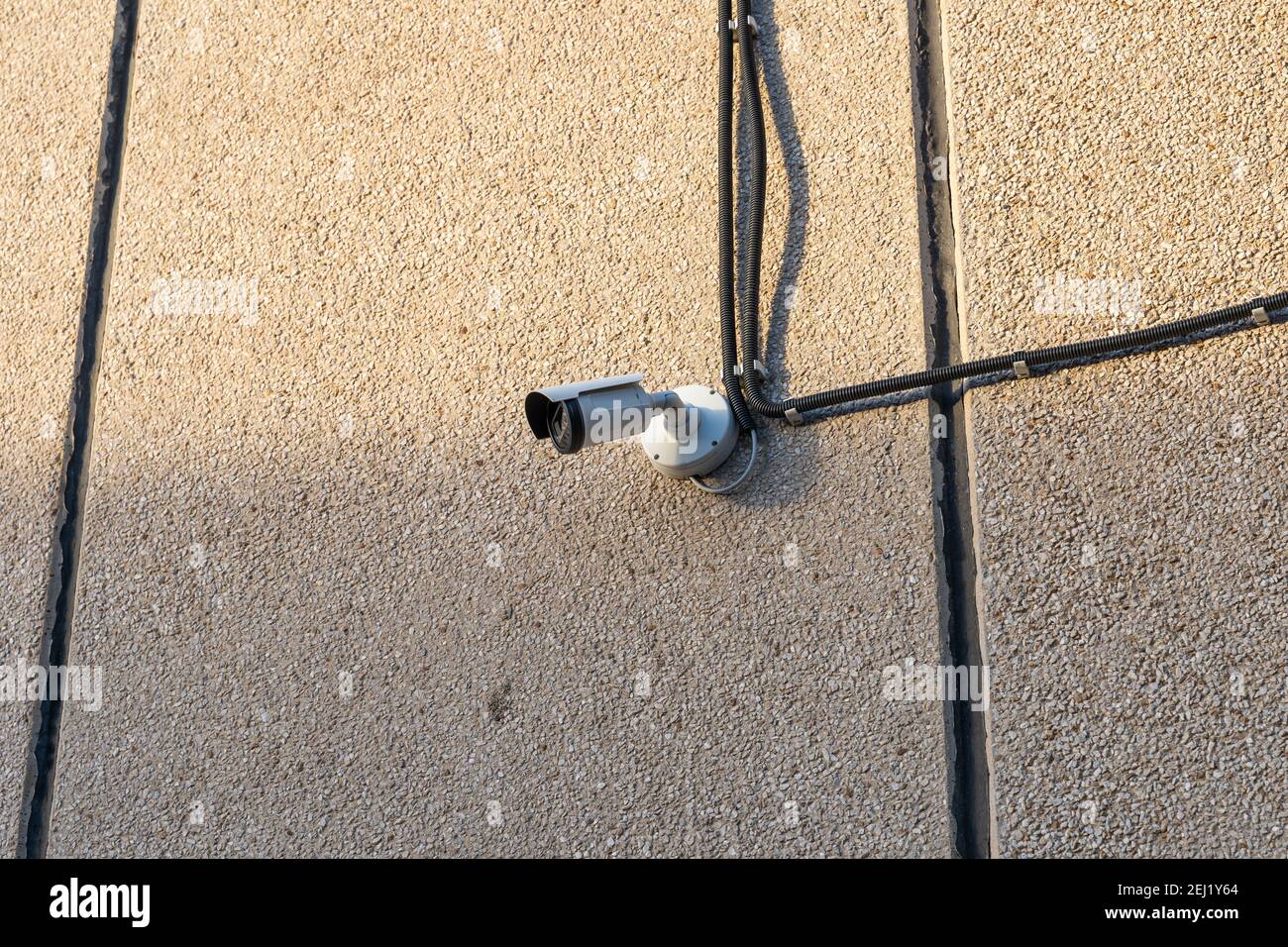 Telecamera TVCC montata su una parete all'esterno di un edificio per monitorare un'area al fine di prevenire furti e crimini. Precauzioni di sicurezza per l'osservazione della proprietà. Foto Stock