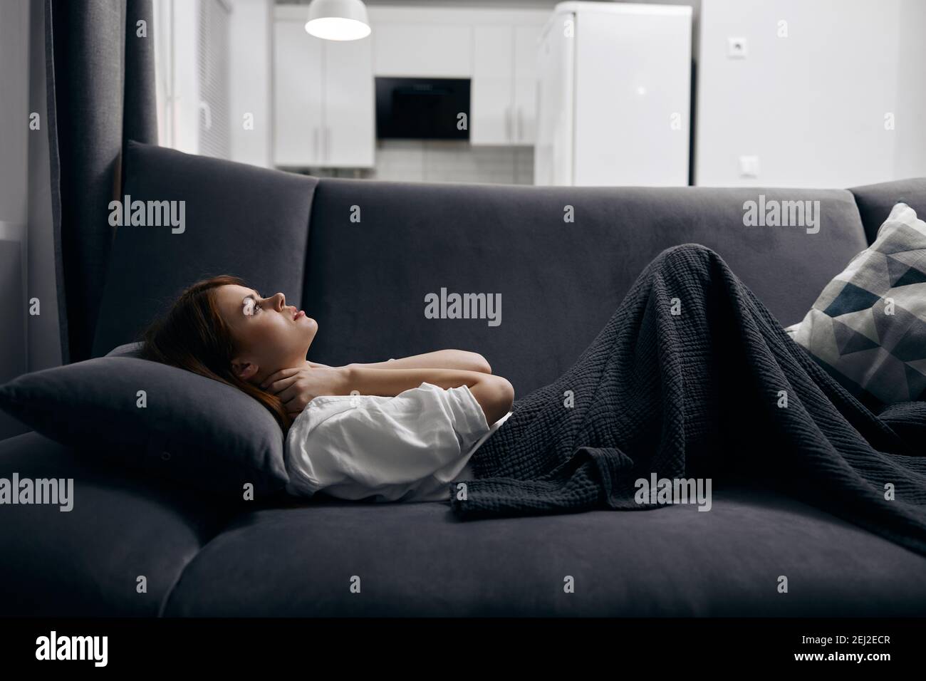 donna coperta con una coperta sta riposando sdraiato sul divano Foto stock  - Alamy