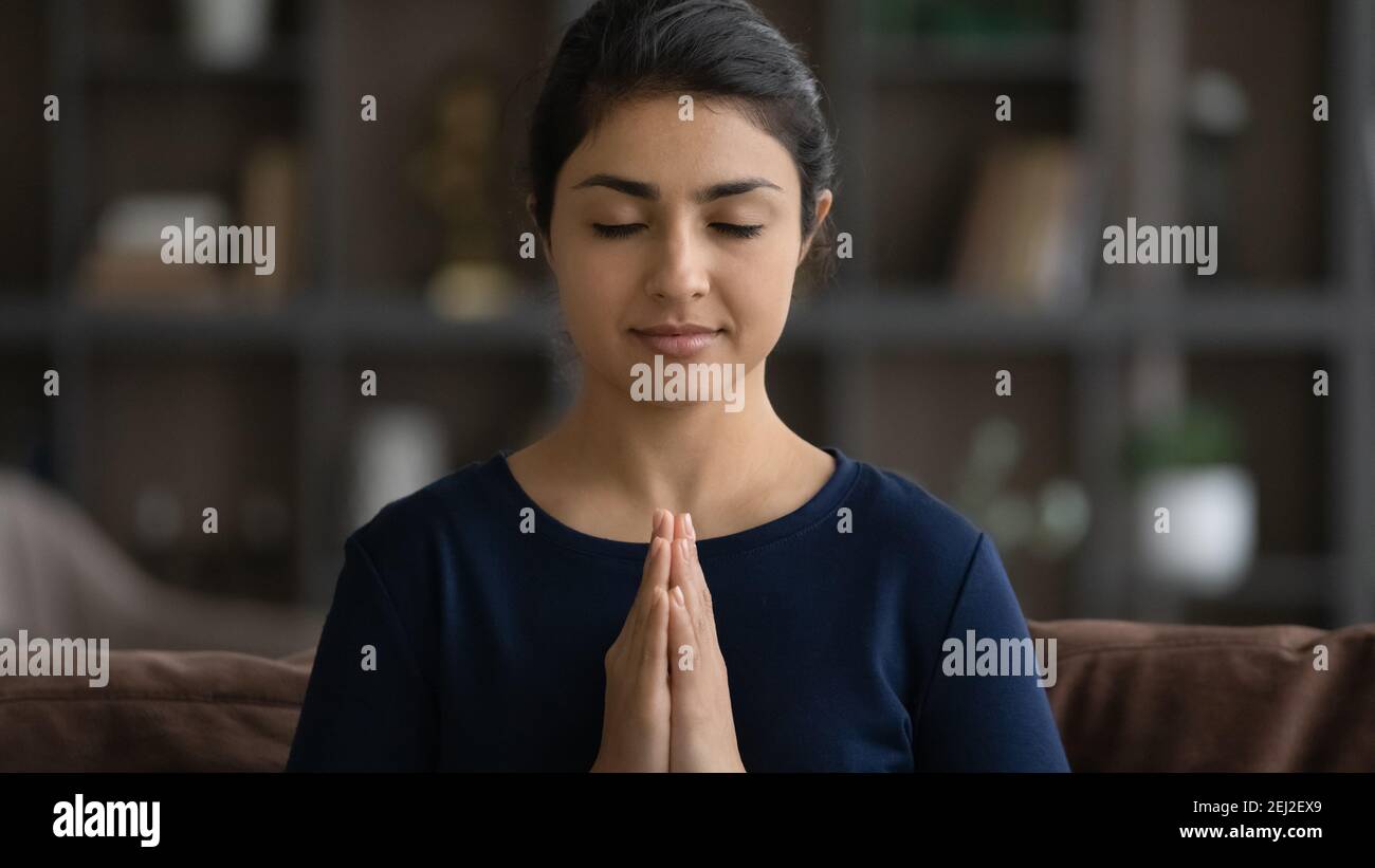 Calma donna indiana meditare con le mani in preghiera Foto Stock