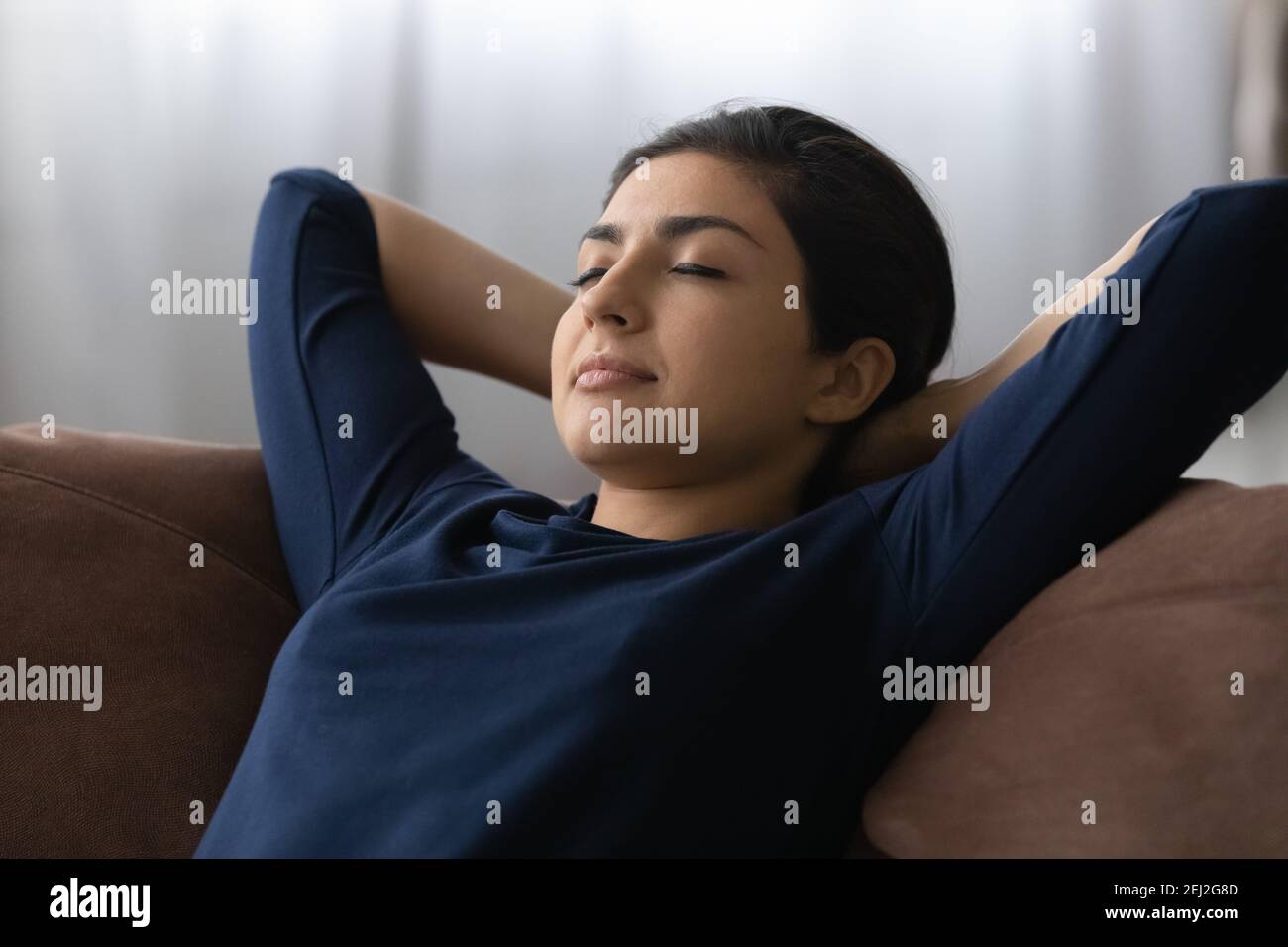 Calma donna indiana rilassarsi dormire sul divano di casa Foto Stock