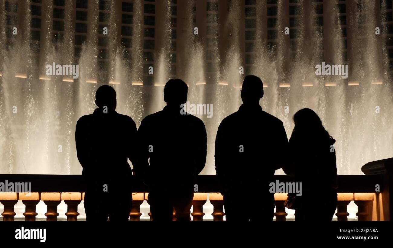 LAS VEGAS, NEVADA USA - 13 dic 2019: Persone che guardano la fontana Bellagio spettacolo musicale di notte. Silhouette a contrasto e spruzzi di danza scintillanti Foto Stock