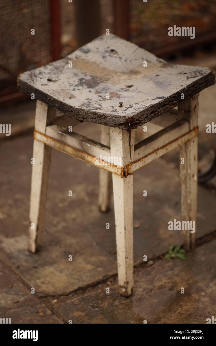 vecchio sgabello marcio con supporti per rasatore nel cortile. Foto Stock