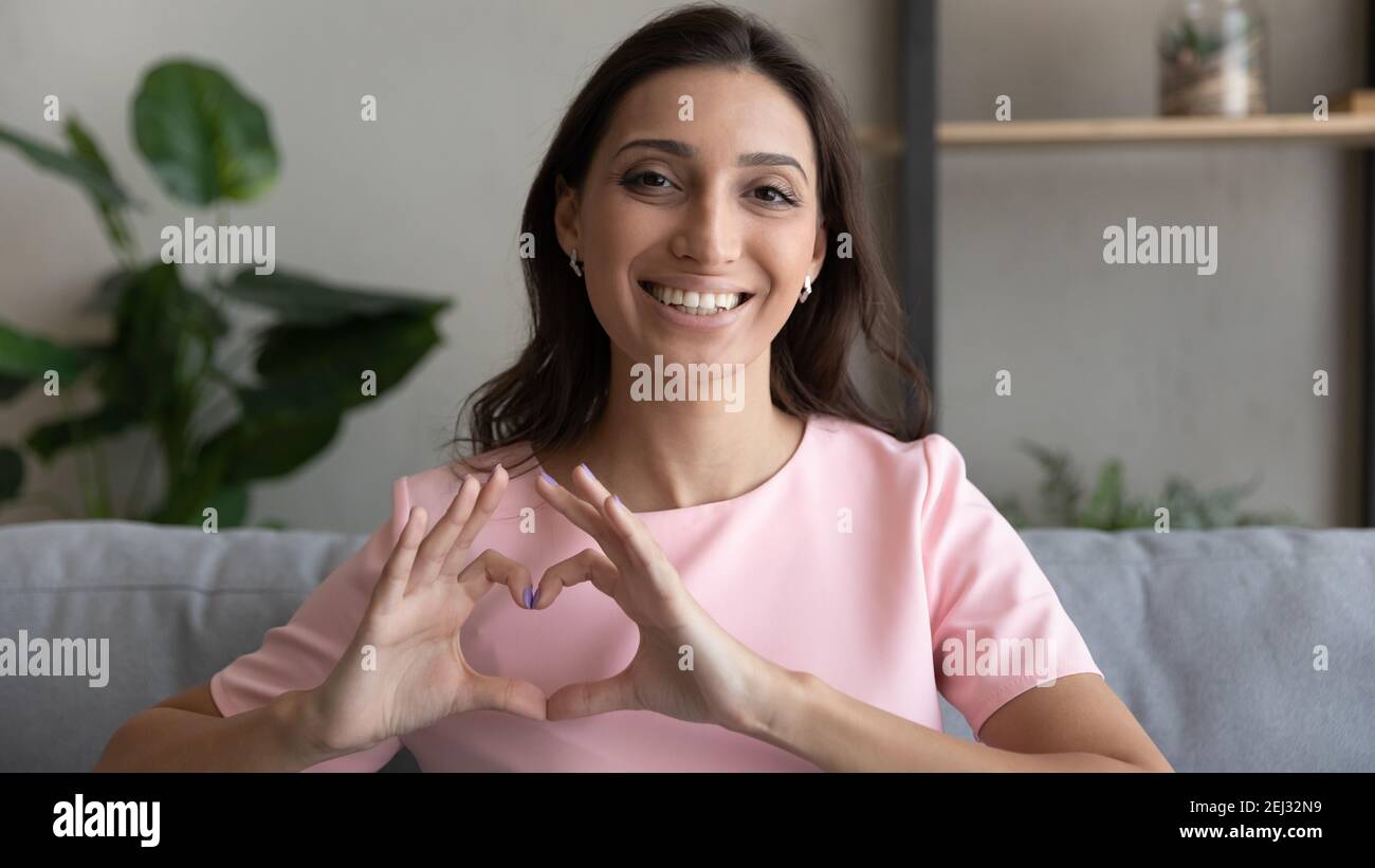 Signora indiana che unisce le mani nel segno d'amore che fa la confessione romantica Foto Stock