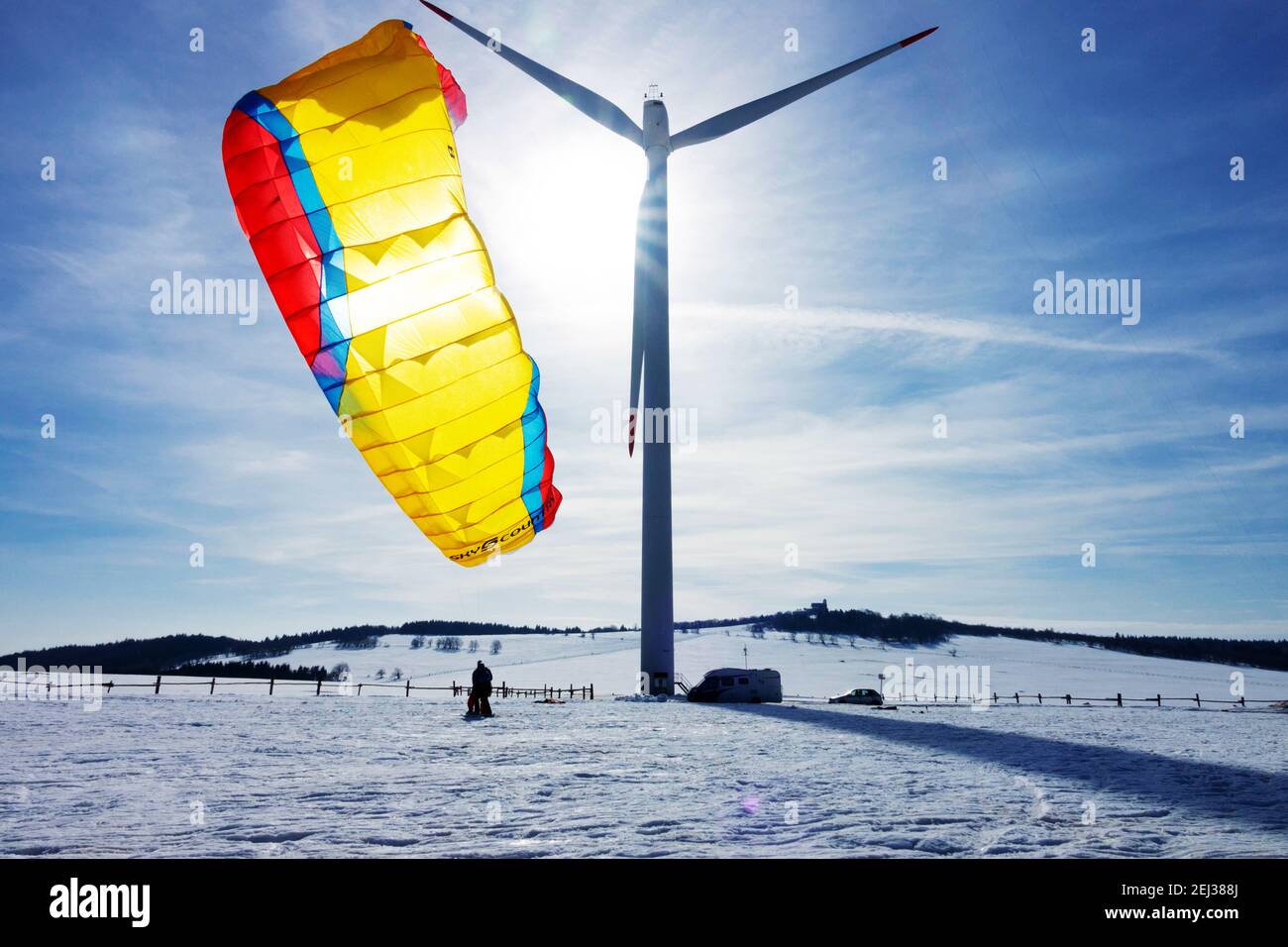 Sport invernali in neve, aquilone sulla neve aperto contro il cielo con sole, turbina eolica invernale panoramica turbine eoliche neve neve ambiente invernale Krusne Hory Erzgebirge Foto Stock