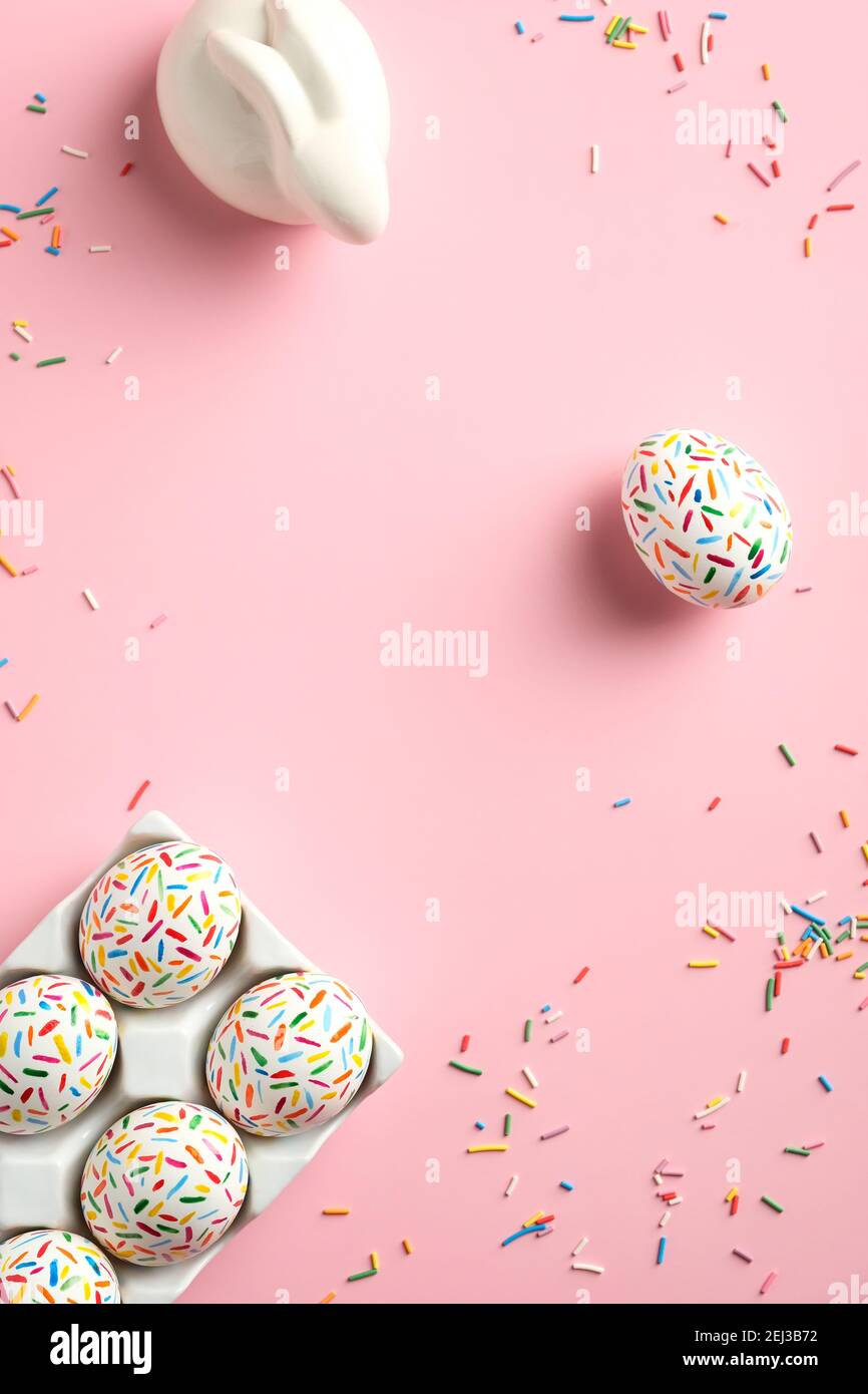 Biglietto d'auguri di Pasqua con coniglietto, uova colorate e dolci. Disposizione piatta, vista dall'alto, verticale. Progettazione di banner sui social media. Foto Stock