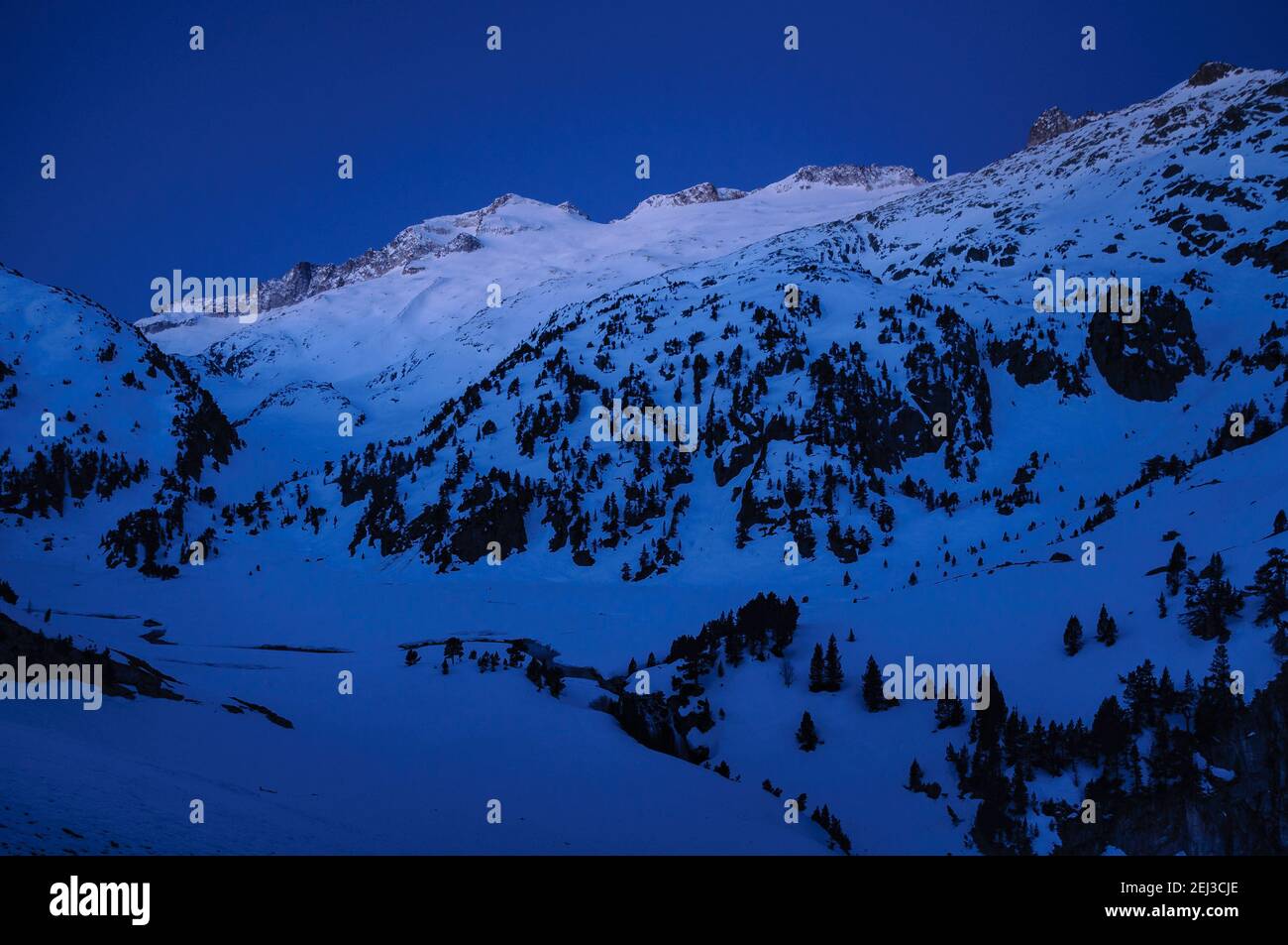 Alba invernale sulla cima di Aneto e sul massiccio del Maladetas, vista dal Plan d'Aigualluts (Valle del Benasque, Pirenei, Spagna) Foto Stock