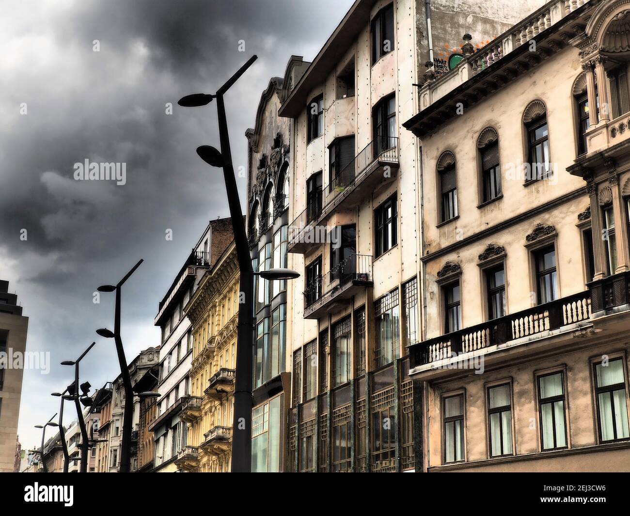 Vecchi edifici antichi ornati ristrutturati con vista in una strada pedonale nel centro di Budapest, Ungheria in tono drammatico Foto Stock