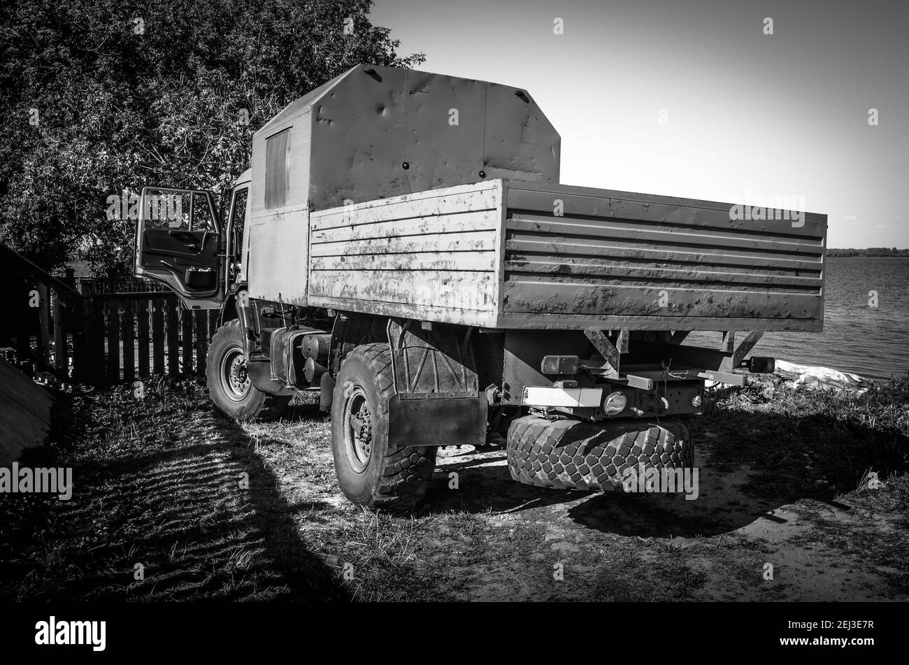 Camion giallo solitario sulla riva di un fiume nella città-isola di Sviyazhsk, Tatarstan. Bianco e nero Foto Stock